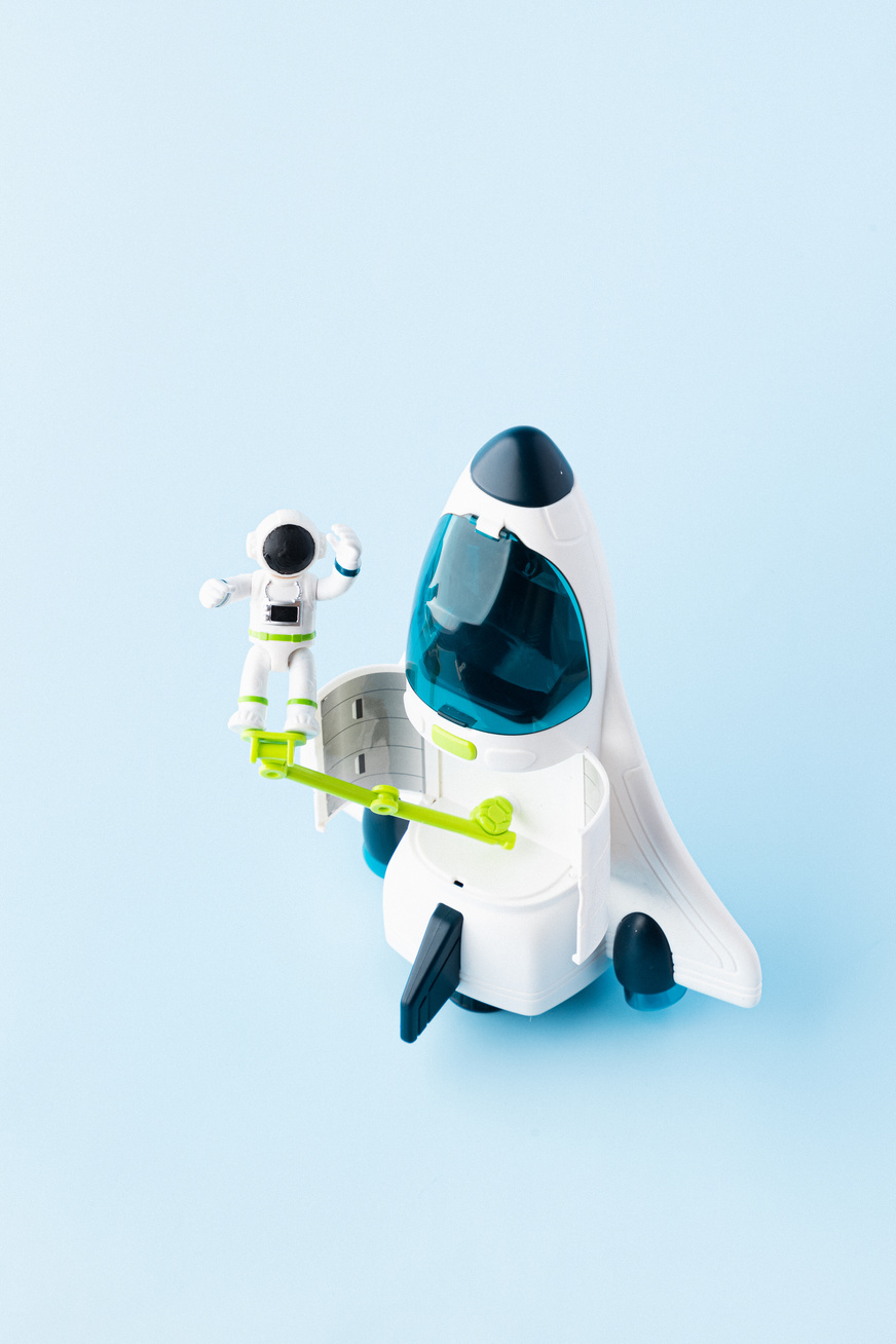 Astronaut and Space Ship Model on Blue Background